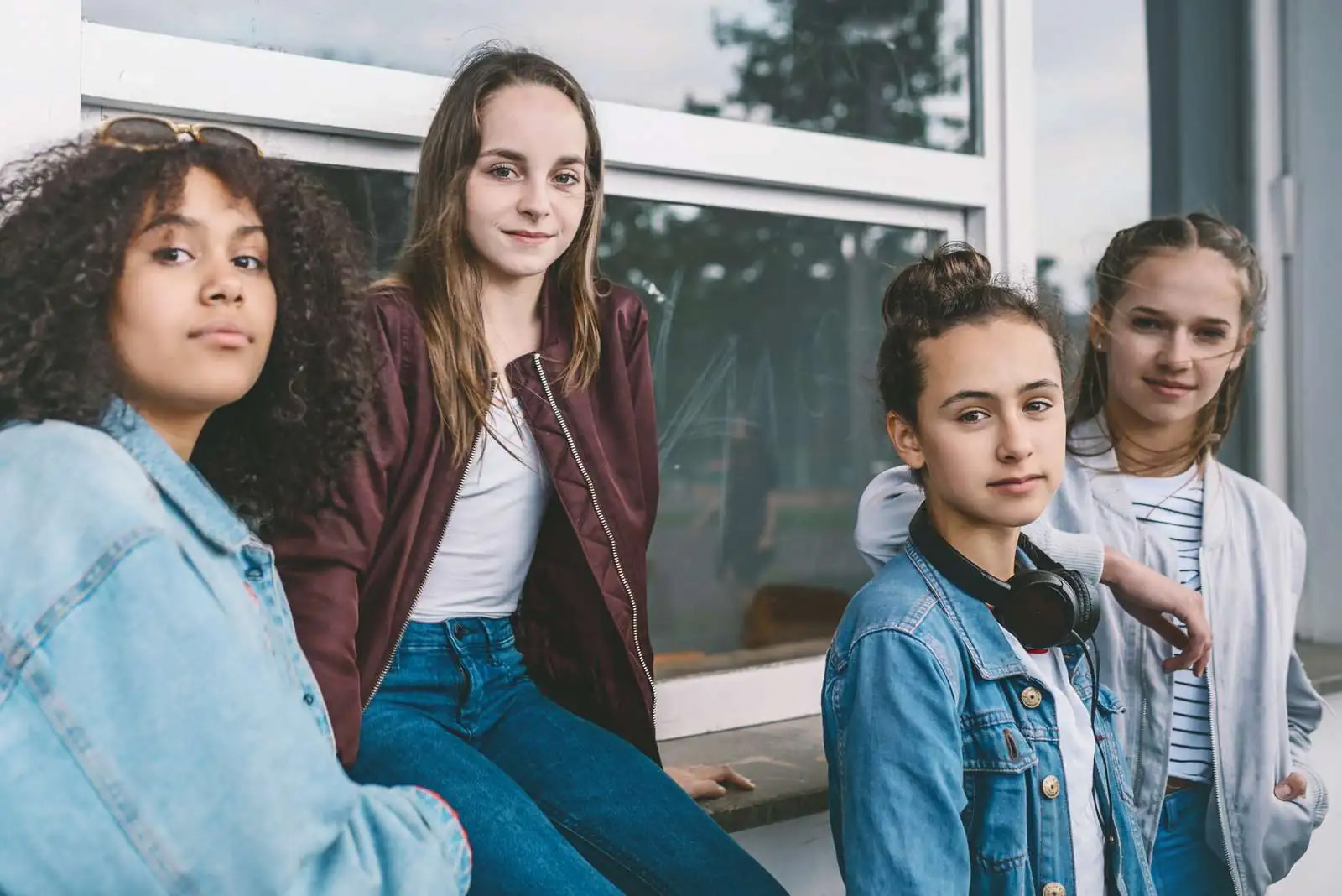 Fire unge piger står op ad en væg