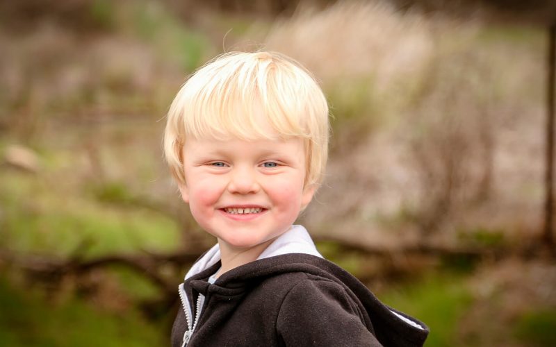 Blond dreng kigger til siden og smiler