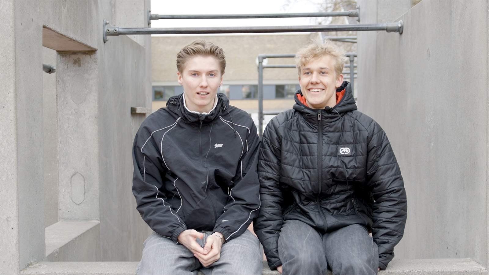 To drenge sidder på en mur
