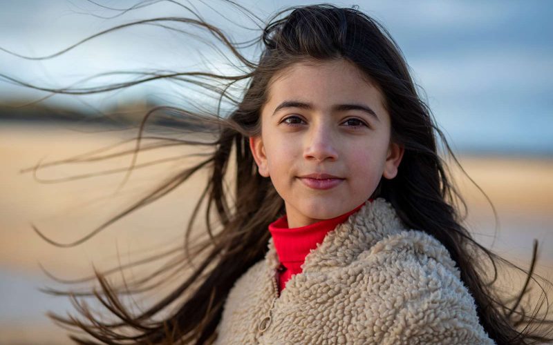 Mørkhåret pige står foran en eng