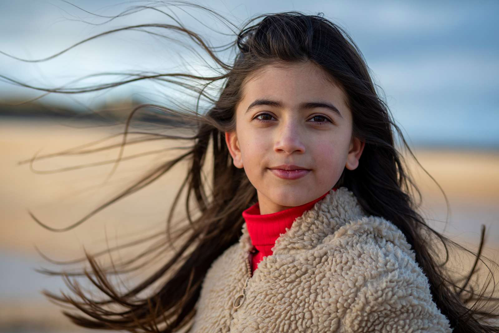 Mørkhåret pige står foran en eng